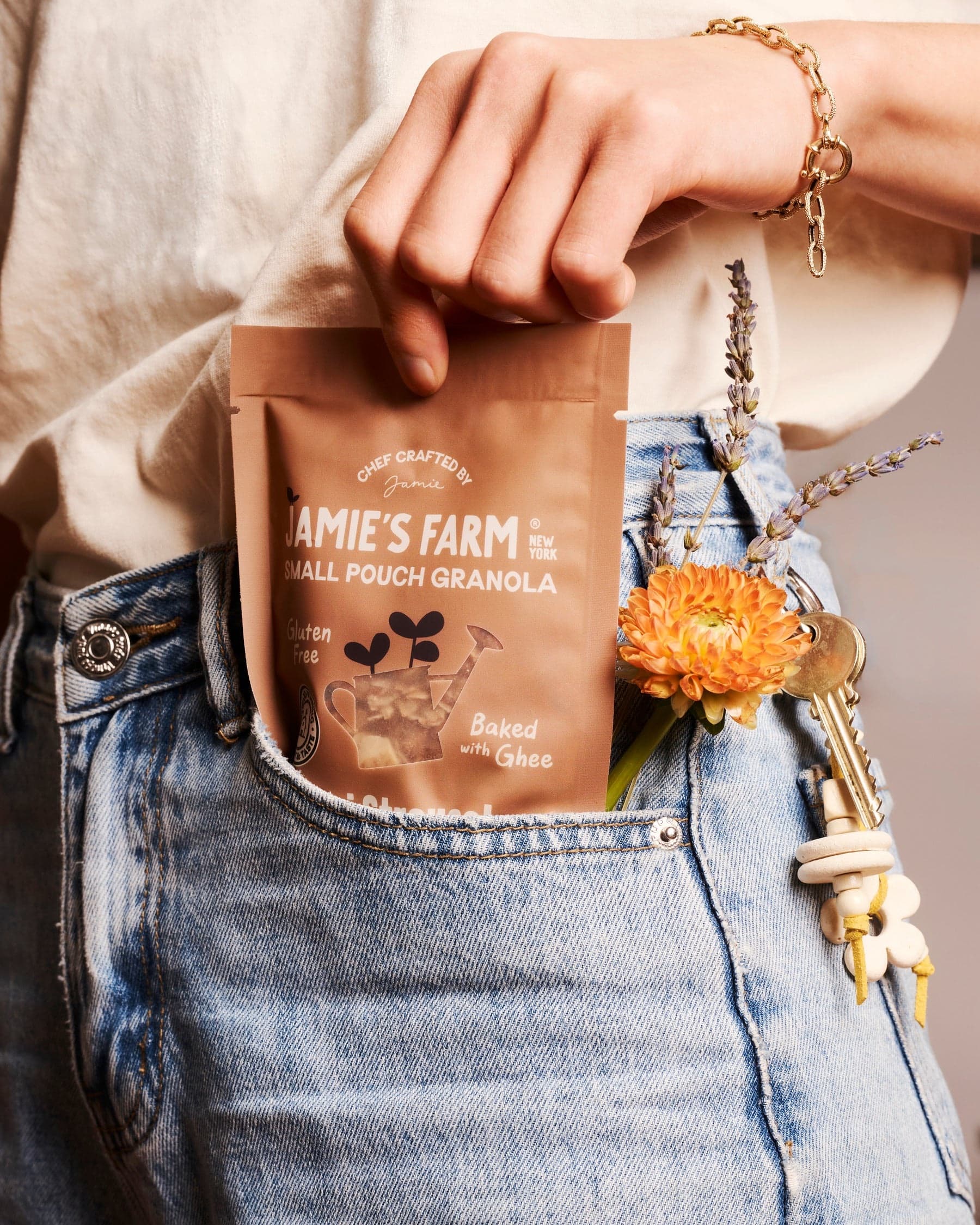 Jamie’s Farm granola tucked into denim with flowers and keys